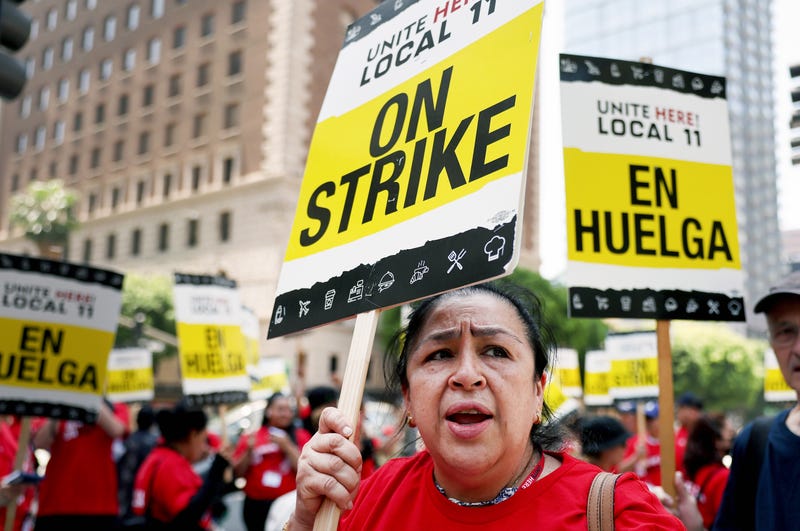hotel workers with picket signs that say on strike