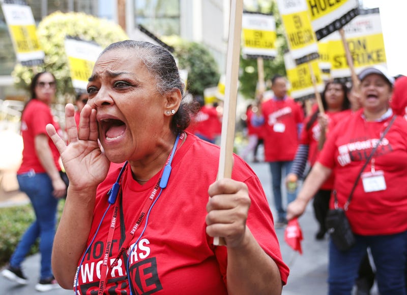 woman on picket line wearing hotel workers on strike t-shirt