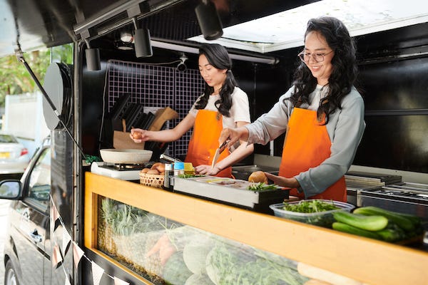 Women making sandwiches for customers in food truck
