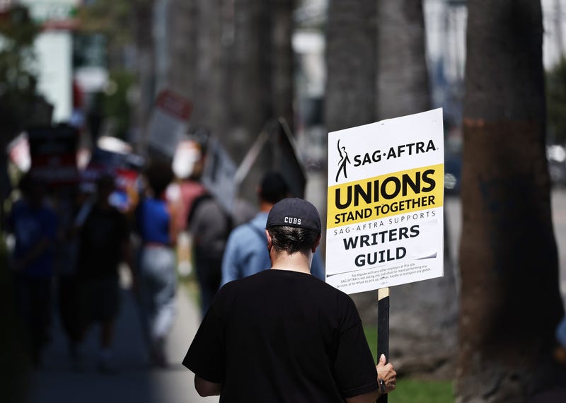 man holding picket sign that says unions stand together