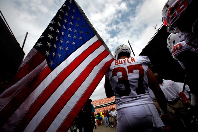 Former Texas Longhorns player Nate Boyer holding the American flag.
