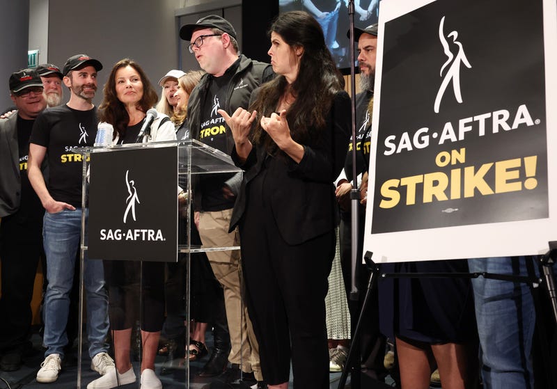 fran drescher and other sag-aftra members at press conference with sign that says sag-aftra on strike