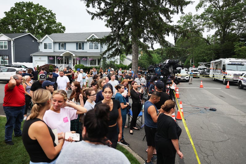 People watch as law enforcement investigates the Massapequa Park home of Rex Heuermann following his arrest in the unsolved Gilgo Beach killings on July 14, 2023