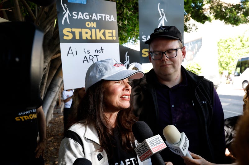 fran drescher speaks into mics on sidewalk