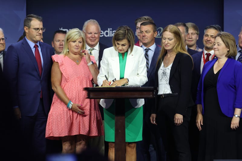 Iowa Governor Kim Reynolds signs into law a bill that will ban most abortions after around six weeks of pregnancy during a visit to the Family Leadership Summit on July 14, 2023 in Des Moines, Iowa.
