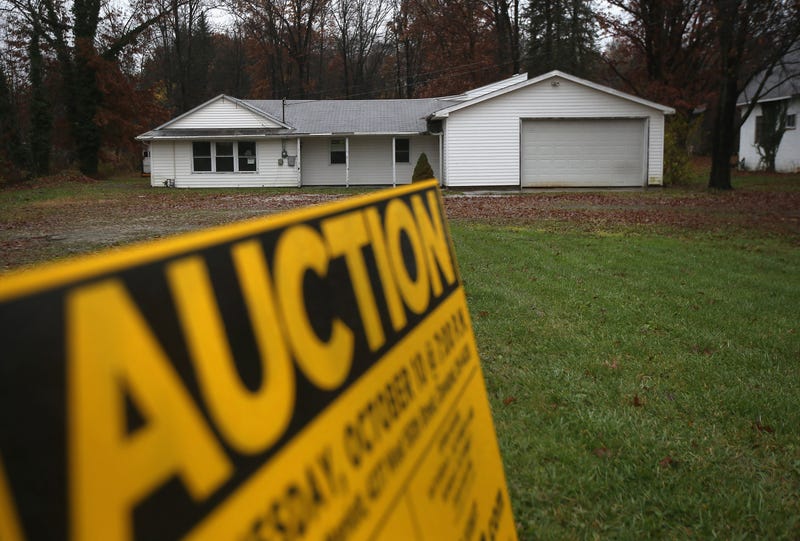 An auction sign outside of a foreclosed home