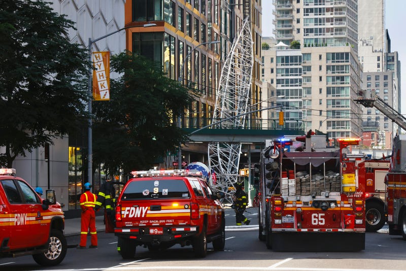 Firefighters inspect a construction crane that caught fire and collapsed in Hell's Kitchen on July 26, 2023