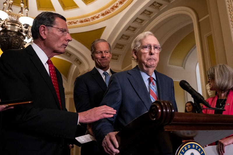(L-R) Sen. John Barrasso (R-WY) reaches out to help Senate Minority Leader Mitch McConnell (R-KY) after McConnell froze and stopped talking at the microphones during a news conference after a lunch meeting with Senate Republicans U.S. Capitol 26, 2023 in Washington, DC.