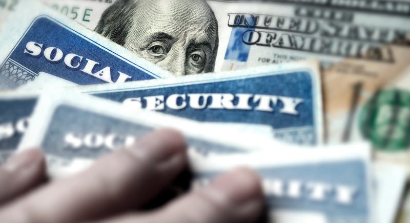 Social security cards over a $100 bill.
