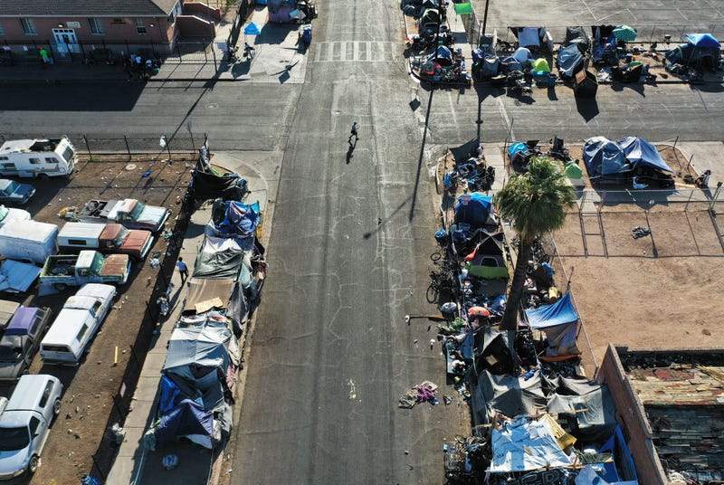 In an aerial view, people walk through a section of the 'The Zone', Phoenix's largest homeless encampment, amid the city's worst heat wave on record on July 26, 2023 in Phoenix, Arizona. While Phoenix endures periods of extreme heat every year, today marked the 27th straight day of temperatures reaching 110 degrees or higher, a new record amid a long duration heat wave in the Southwest. Extreme heat kills more people than hurricanes, floods and tornadoes combined in an average year in the U.S. Unhoused people are at an especially high risk of heat-related illness or death. (Photo by Mario Tama/Getty Images)