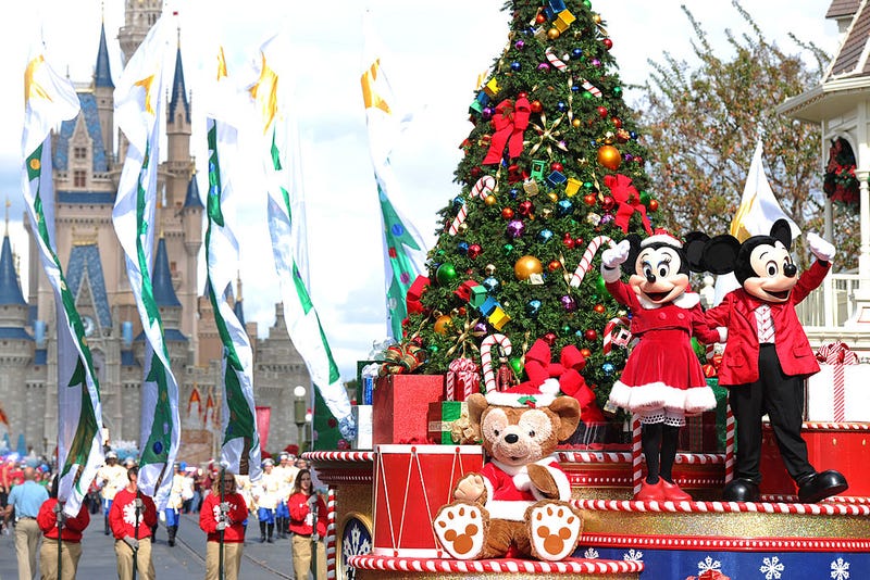 Mickey and Minnie Mouse wave to the crowd while taping the "Disney Parks Christmas Day Parade" TV special in the Magic Kingdom park at Walt Disney World