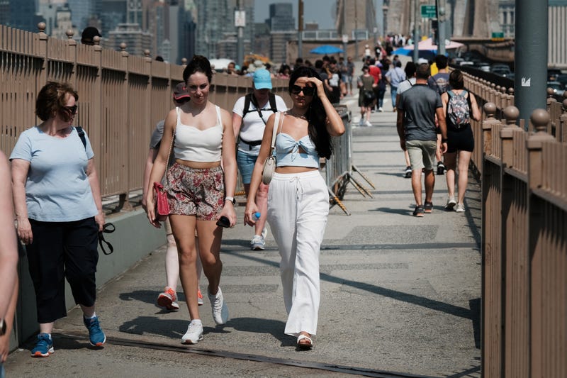 People walk on the Brooklyn Bridge during the heat wave on July 27, 2023