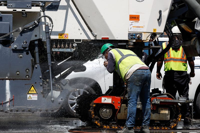 A worker cools off on a construction site.