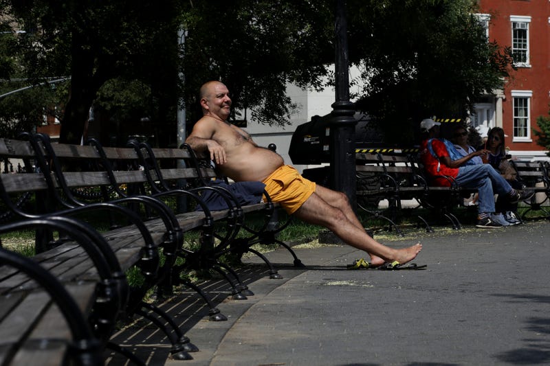 A man enjoys a sunny day at Washington Square Park on July 27, 2023