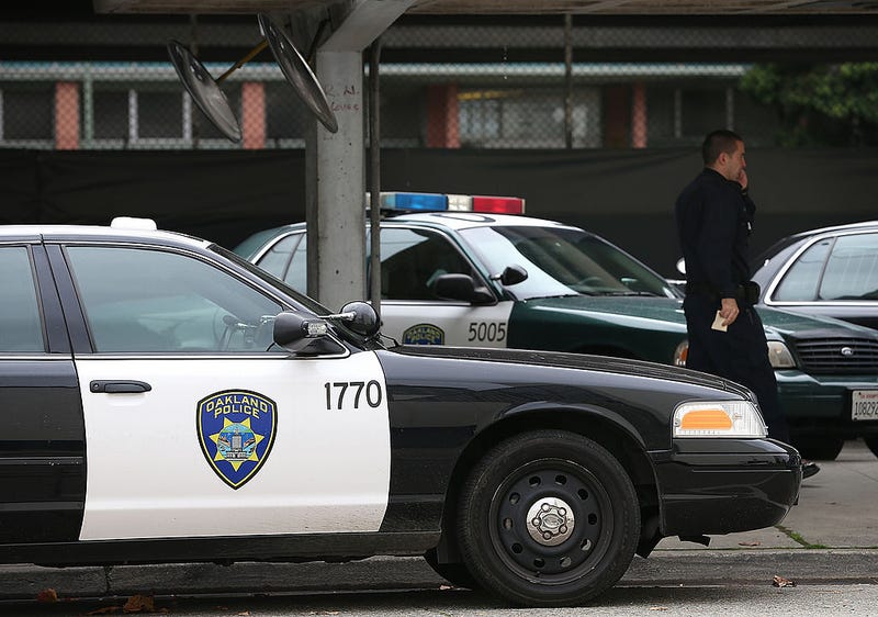  An Oakland Police officer walks by patrol cars at the Oakland Police headquarters on December 6, 2012 in Oakland, California.