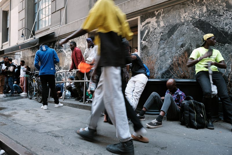 Recently arrived migrants wait outside the Roosevelt Hotel, which has been made into a reception center, last week