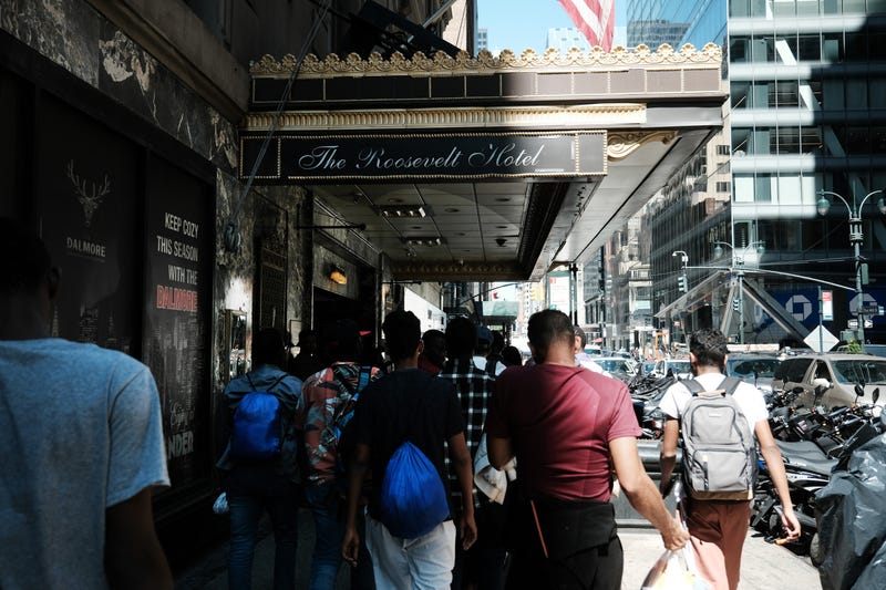 Hundreds of recently arrived migrants to New York City wait outside of the Roosevelt Hotel, which has been made into a reception center, as they try to secure temporary housing on July 31, 2023 in New York City.