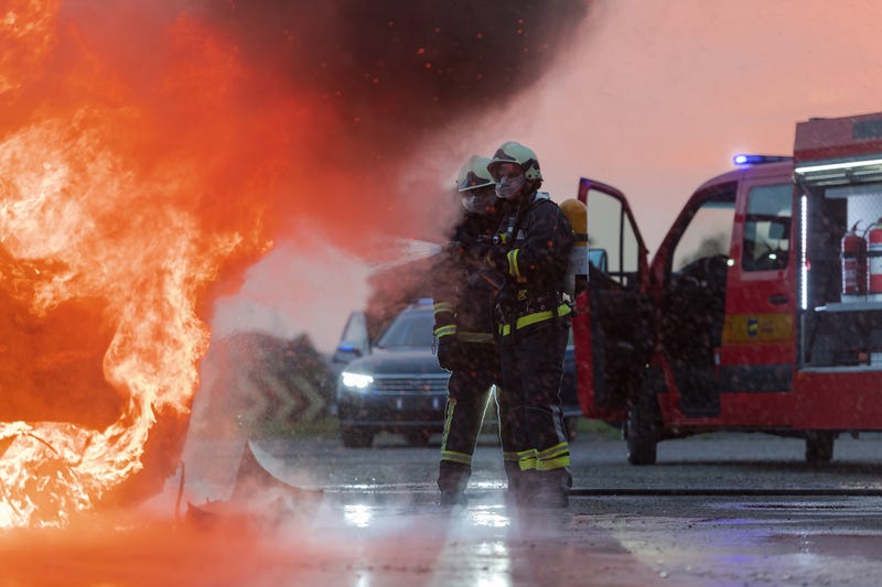 Firefighters battle a car accident blaze
