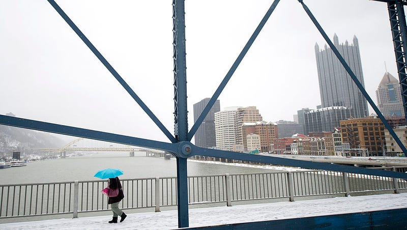 A pedestrian crosses the Smithfield Street Bridge on a snowy day