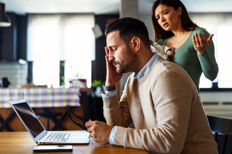 Father businessman try to work on laptop from home while wife arguing with him. Work from home concept.