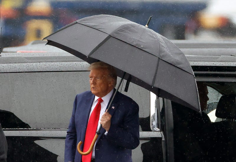 donald trump holding an umbrella