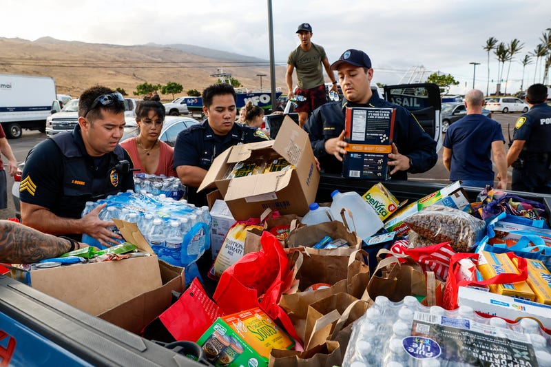 Maui police officers help pack truckloads of food and supplies in Maalaea, Maui on Aug. 10, 2023.