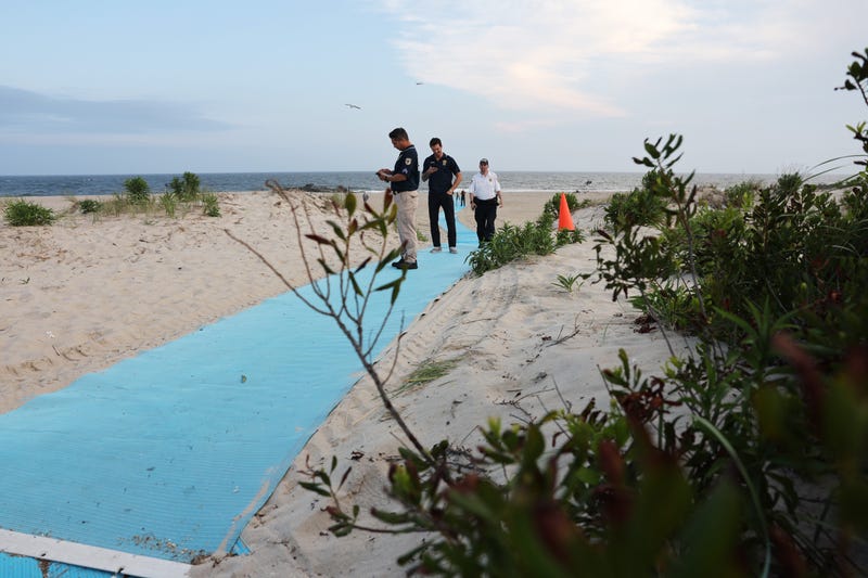 Police gather along Rockaway Beach at 59th Street after a shark attack on Aug. 7, 2023