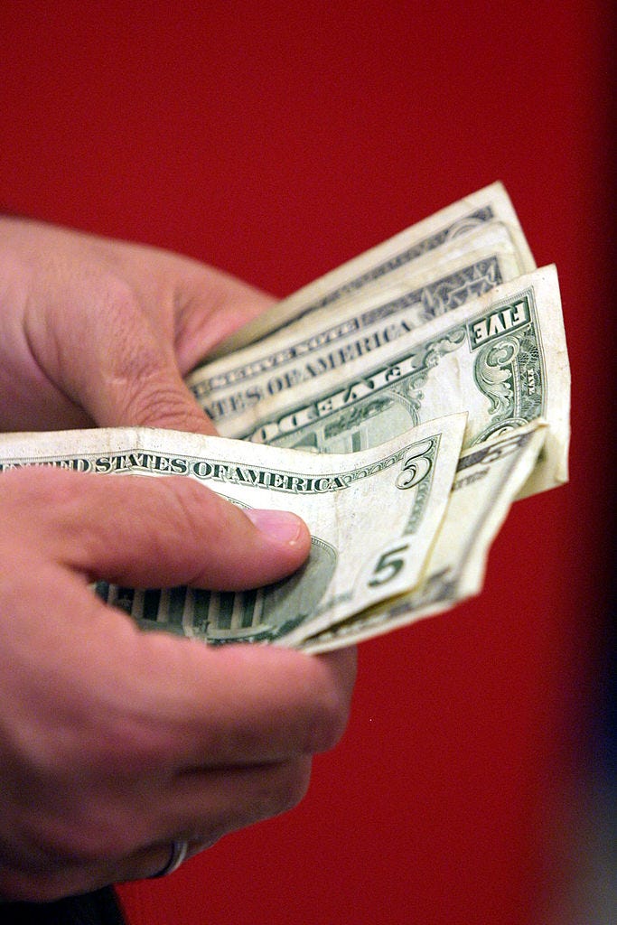 A customer pays for his purchases at a Target department store July 27, 2001 in Miami-Dade County, FL. Consumers are being lured by back-to-school sales and a special statewide tax-free shopping period that ends August 5, at the same time that many taxpayers are receiving federal rebate checks. (Photo by Joe Raedle/Getty Images)