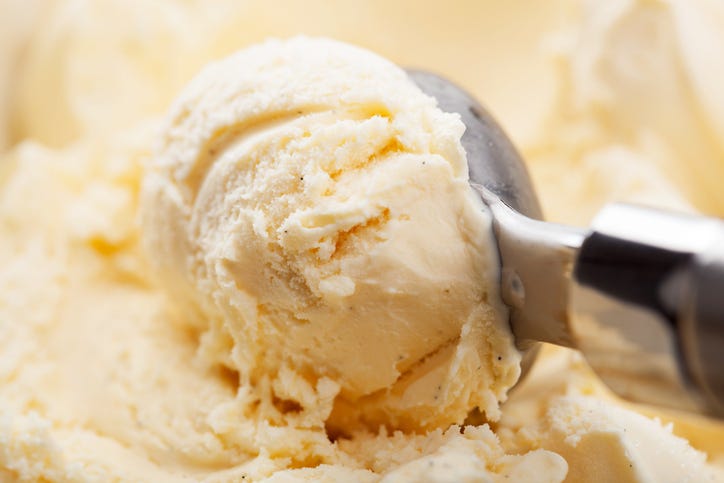 Vanilla ice cream being scooped up. 