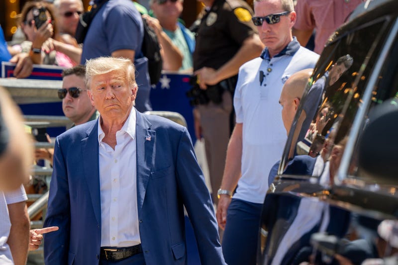 Republican presidential candidate and former U.S. President Donald Trump is directed to his vehicle after speaking at the Steer N' Stein bar at the Iowa State Fair on August 12, 2023 in Des Moines, Iowa. 