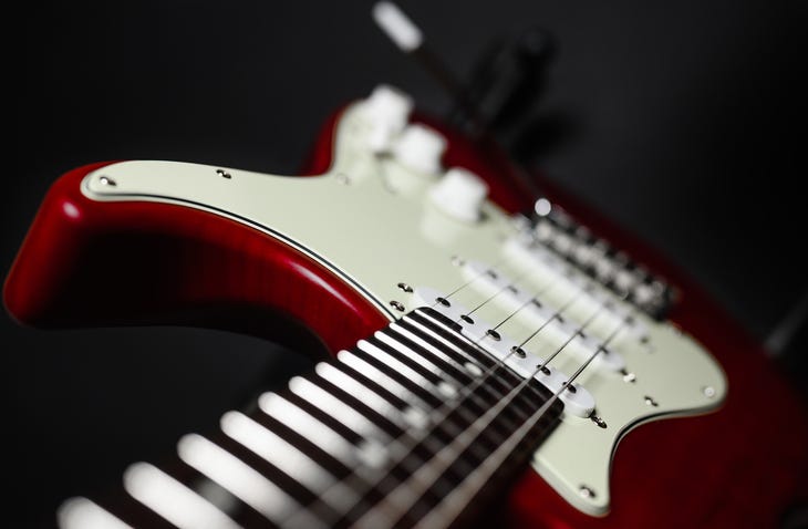 Close-up of a red electric guitar on a black background