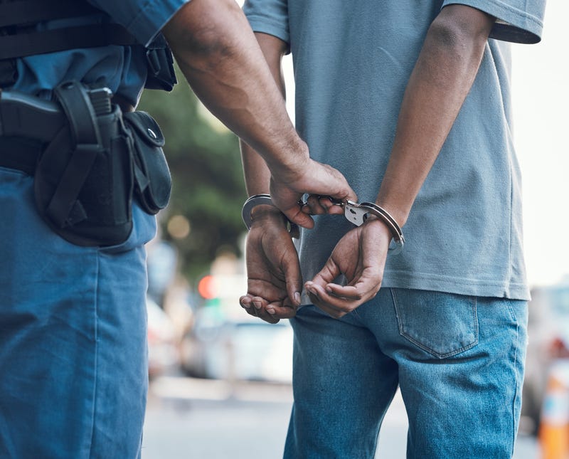 A handcuffed man is taken into custody.