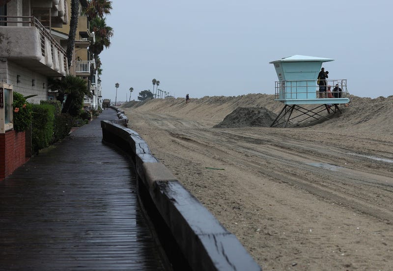 A sand berm runs along the beach outside of beachfront homes on August 20, 2023 in Long Beach, California. 
