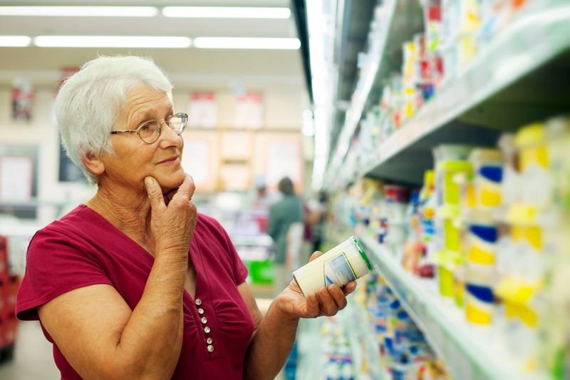 Senior citizen woman at grocery store stock photo. 