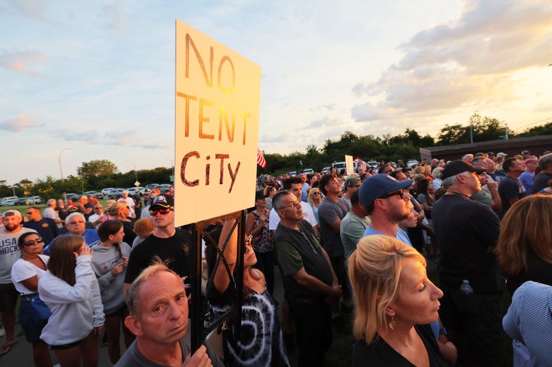 People attend an anti-migrant protest lead by Guardian Angels founder Curtis Sliwa at Floyd Bennett Field on August 22, 2023 in the Marine Park neighborhood of the Brooklyn borough New York City.