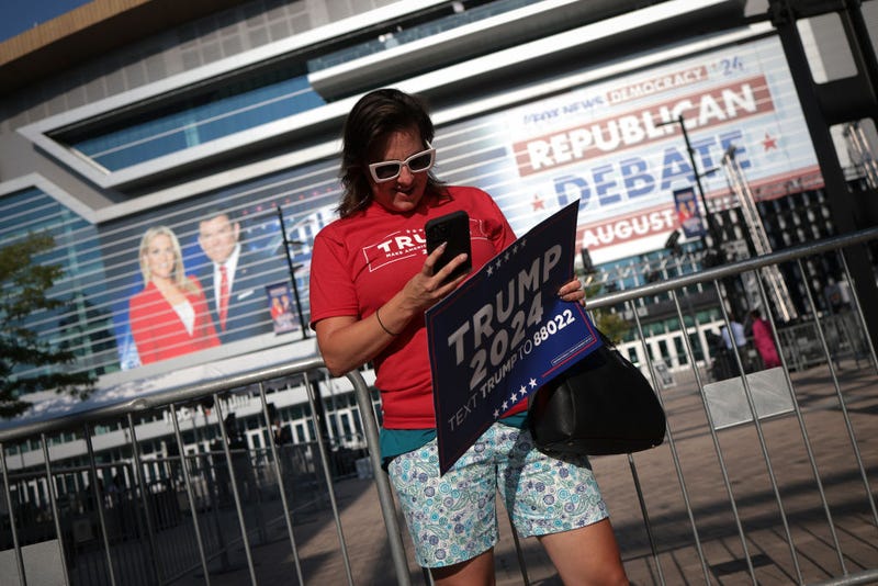 A supporter of Republican presidential candidate former U.S. President Donald Trump tours the exterior of the Fiserv Forum on August 23, 2023 in Milwaukee, Wisconsin.