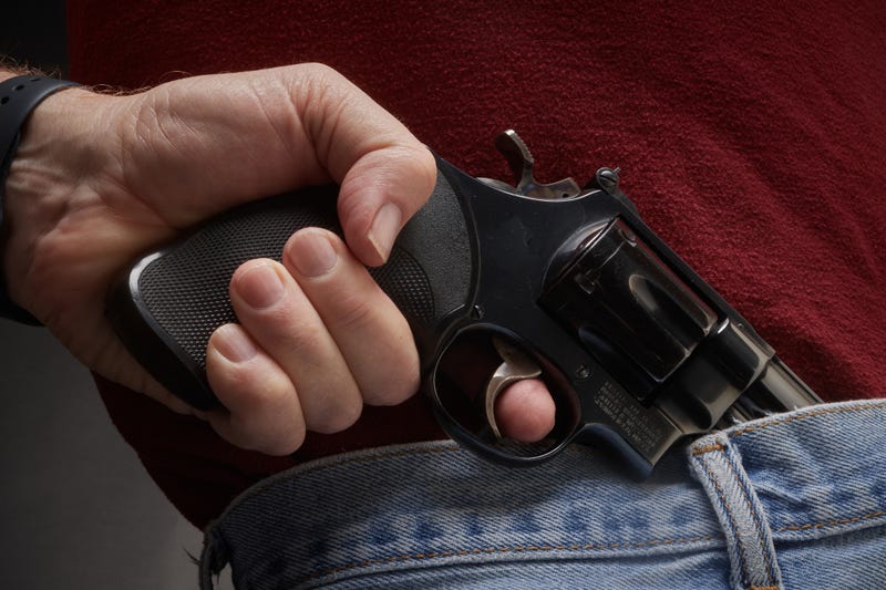Man pulling a gun from his waistband