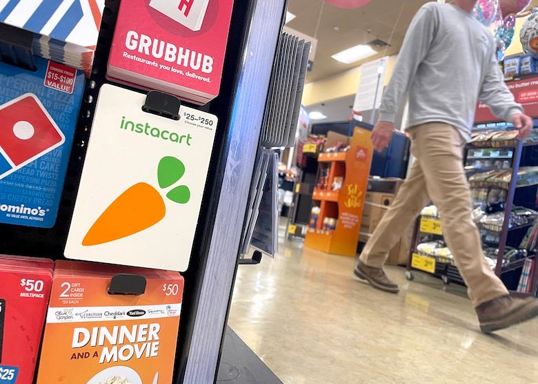 Man walking past a gift card display