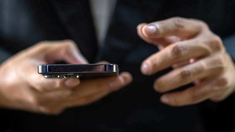 Closeup of a man's hands using an iPhone