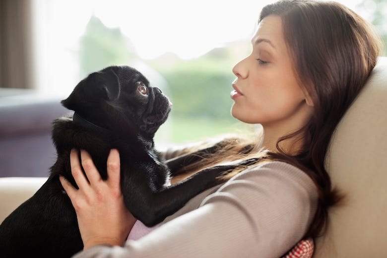 Woman talking to her dog on a sofa