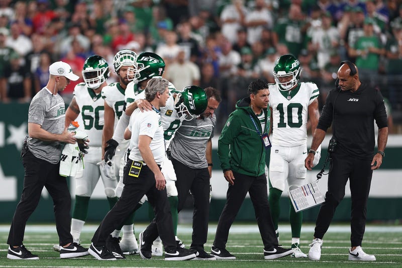 Quarterback Aaron Rodgers #8 of the New York Jets is helped off the field by team trainers after an injury during the first quarter of the NFL game against the Buffalo Bills at MetLife Stadium on September 11, 2023 in East Rutherford, New Jersey. 