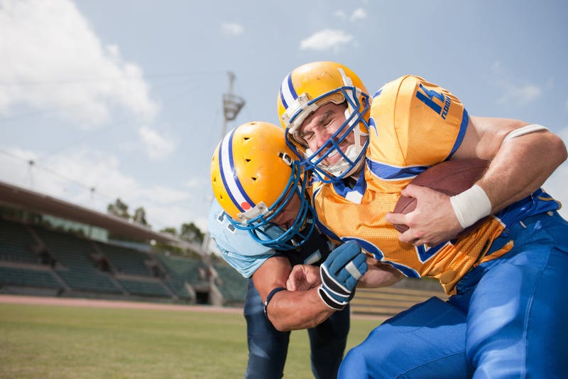 A pair of football players collide mid-game.