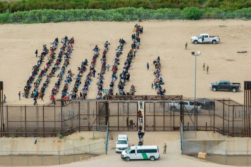 In an aerial view, migrants are seen grouped together while waiting to be processed on the Ciudad Juarez side of the border on September 21, 2023 in El Paso, Texas. 