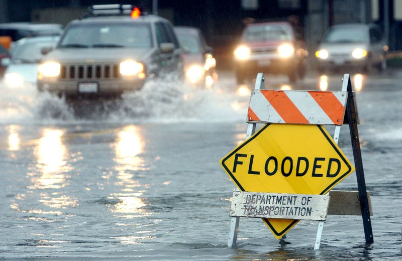 Cars pass through a flooded section of road December 19, 2002 in Mill Valley, California.
