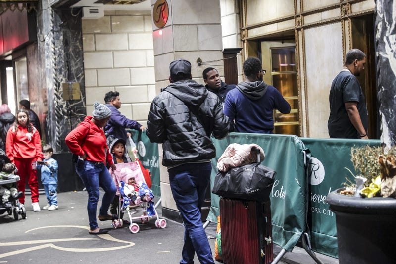 Asylum seekers line up in front of the historic Roosevelt Hotel, which has been converted into a city-run shelter, on Sept. 27, 2023.