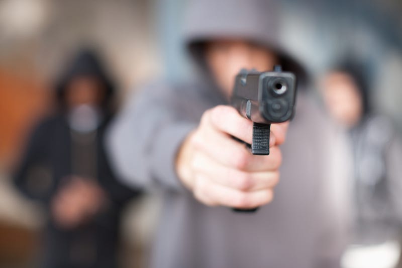hooded teen holding pistol