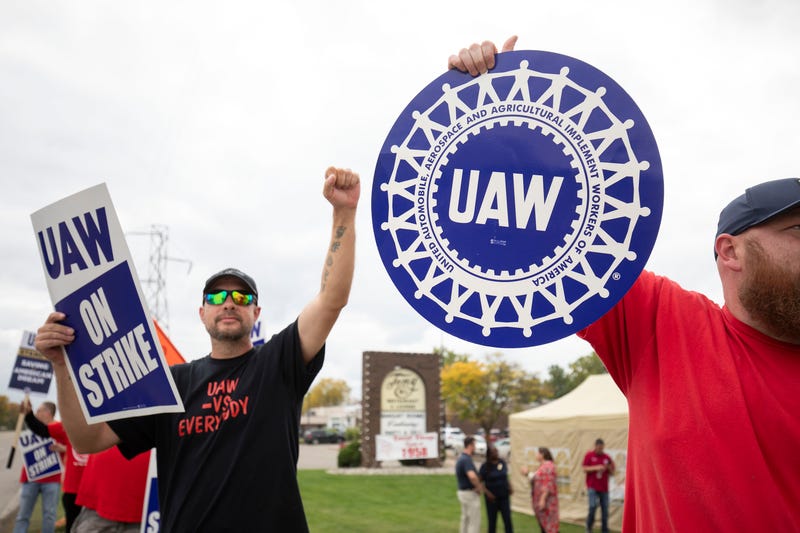 Striking UAW workers holding signs outside the General Motors Lansing Delta Assembly Plant on Friday.