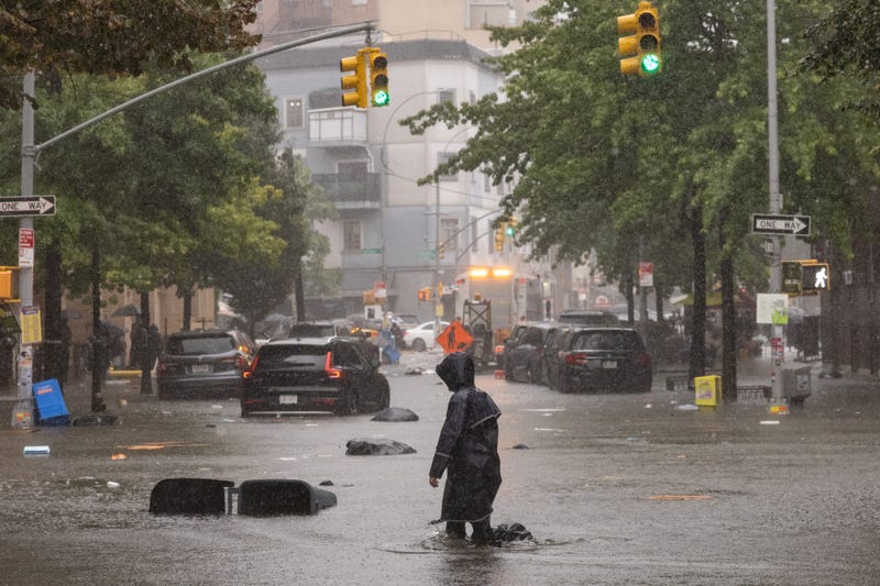 A person walks on a flooded street during a heavy rain storm in the Brooklyn borough of New York City on Friday, Sept. 29, 2023
