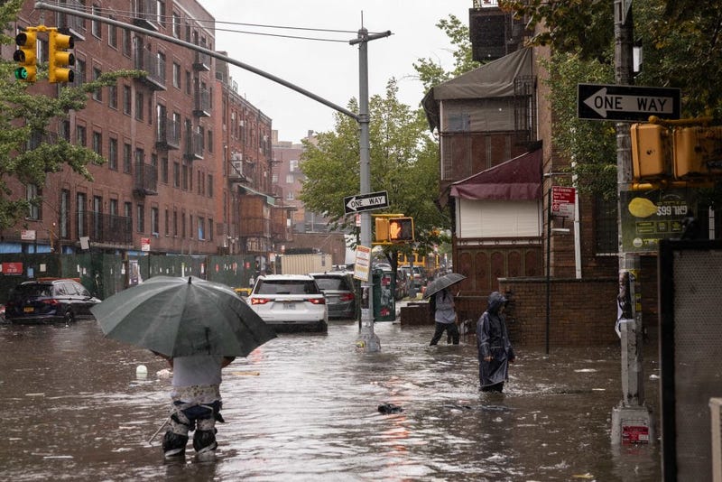 People walk on a flooded street during a heavy rain storm in Brooklyn on Sept. 29.