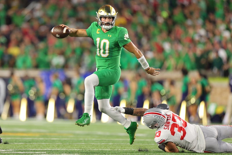 Sam Hartman #10 of the Notre Dame Fighting Irish breaks a tackle from Jack Sawyer #33 of the Ohio State Buckeyes during the first half at Notre Dame Stadium on September 23, 2023 in South Bend, Indiana